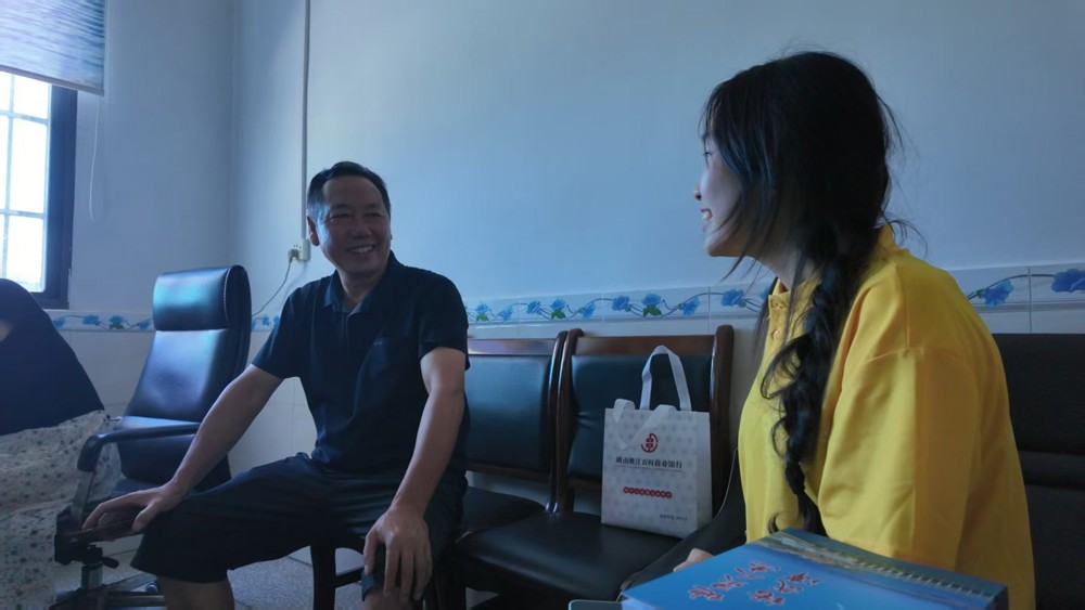 图2 团队成员与村党总支部副书记熊劲松交谈