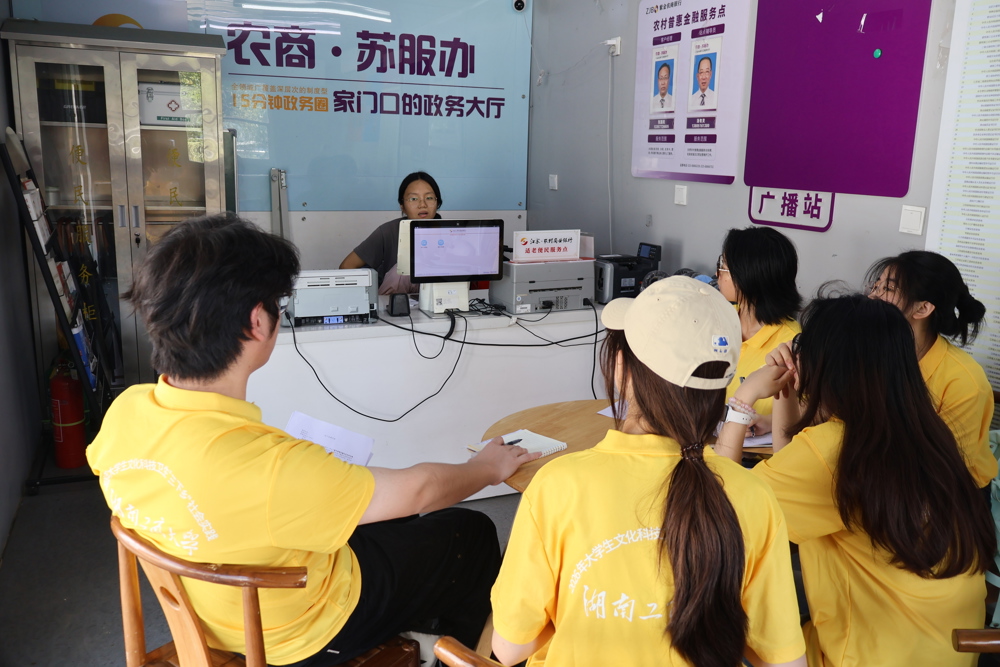 图2：图为队员参观农商苏服办服务窗口了解一站式便民金融服务流程